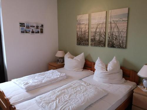 a bedroom with two beds with white sheets and pillows at Lindenhof Wohnung 20 in Dahme