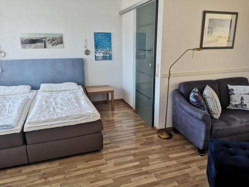 a living room with a bed and a couch at Strandhotel 27 in Dahme