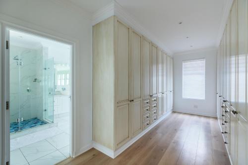 a bathroom with a walk in shower and a walk in closet at Plett Azure Guesthouse in Plettenberg Bay