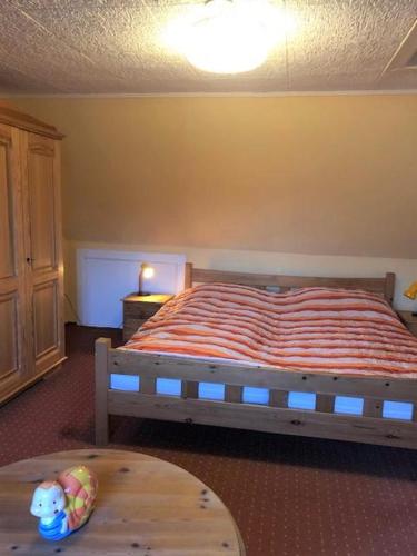 a bedroom with a bed with an orange striped blanket at Memelstrasse 6 in Dahme