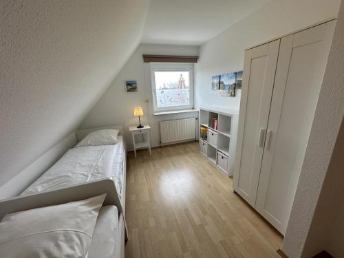 a small bedroom with two beds and a window at Fehmarn 17-1 in Fehmarn