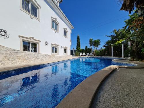 a swimming pool in front of a house at Silver Coast Pool & Resort Villas in Arnal