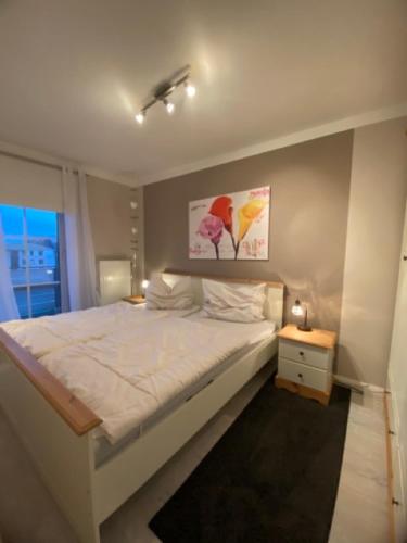a bedroom with a large white bed and a window at Seeschloss Wohnung 22 in Dahme