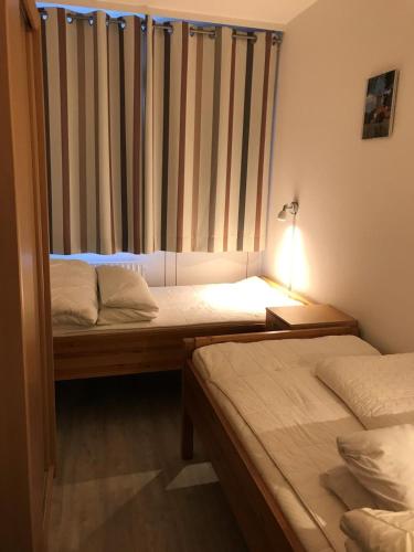 two beds in a room with a window and a lamp at Strandhotel Wohnung 61 in Dahme