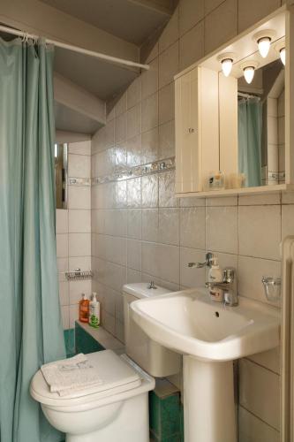 a bathroom with a toilet and a sink at 3BD Apartment in the Center - Self check in in Patra