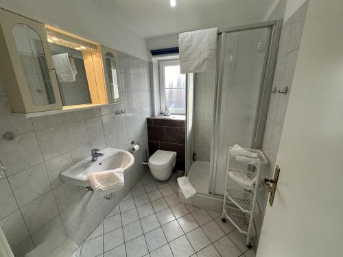 a bathroom with a sink and a shower and a toilet at Fehmarn 17-6 in Fehmarn