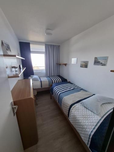 a hotel room with two beds and a desk at Strandhotel Wohnung 30 in Dahme