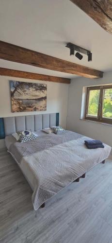 two beds in a white room with two windows at Pokoje Gościnne w Spichlerzu in Ustka