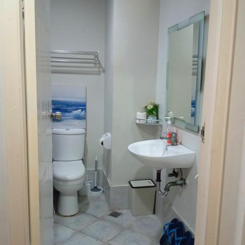 a bathroom with a toilet and a sink at Amani Airport Haven - 726 in Pusok