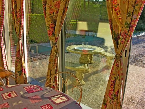 a glass door with a table and a tableolitics at Cabanes flottantes et gîtes au fil de l'eau in Colleville