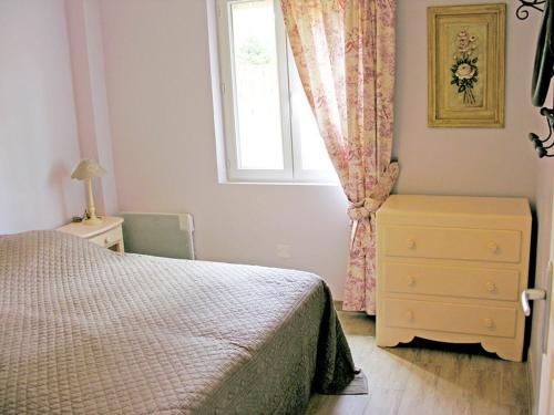 a bedroom with a bed and a window and a dresser at Cabanes flottantes et gîtes au fil de l'eau in Colleville