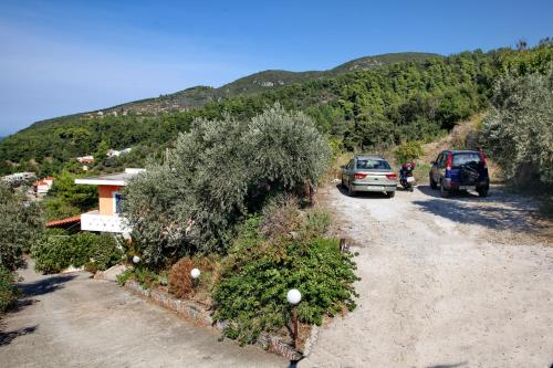 a couple of cars parked on a dirt road at Irene' s Paradise in Skopelos Town