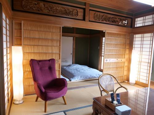 a room with a bed and a chair and a table at Inn Azur in Yamatotakada
