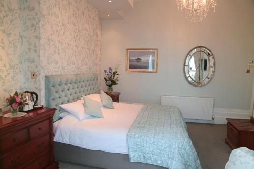 a bedroom with a bed and a mirror and a dresser at East Beach Hotel in Eastbourne