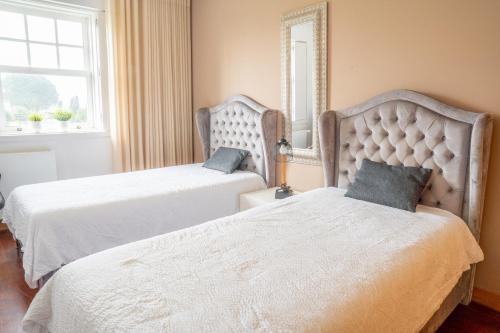 a bedroom with two beds and a mirror at Refúgio das Velhas in Vila Nova de Cerveira