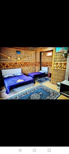 a bedroom with two beds and a rug at Baku "ISR" Guest House in Sǝnqǝçal Stansiyası