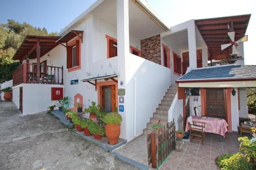a white house with a porch and a table at Irene' s Paradise in Skopelos Town