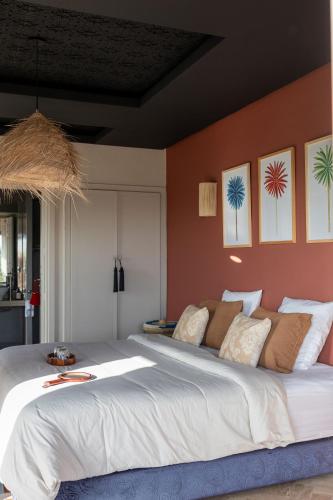 a bedroom with a large bed with orange walls at Smala Beldi Guest House in Essaouira