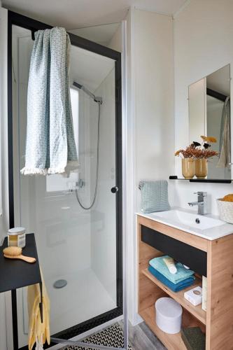 a bathroom with a shower and a sink at Camping Le Bosquet in Domme