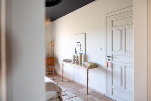 a white room with a door and a table at Smala Beldi Guest House in Essaouira