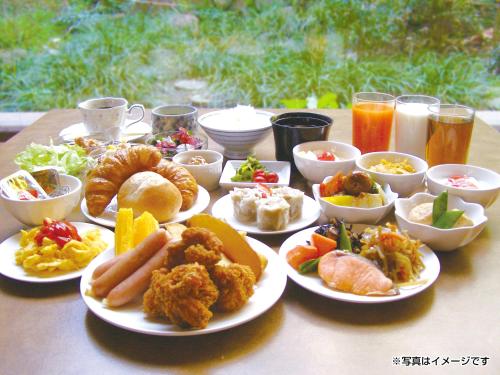 a table with plates of food on a table at Hotel Grand Terrace Chitose in Chitose