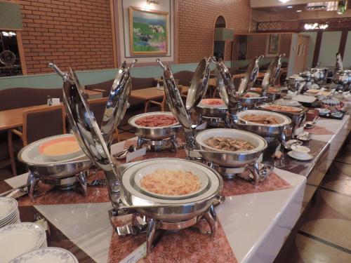 a buffet line with bowls and plates of food at Hotel Grand Terrace Chitose in Chitose