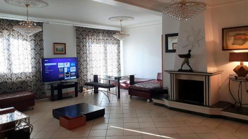 a living room with a fireplace and a tv at Silver Coast Pool & Resort Villas in Arnal
