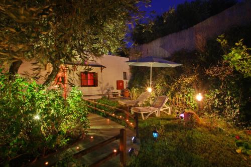 a garden at night with an umbrella and a chair at Irene' s Paradise in Skopelos Town