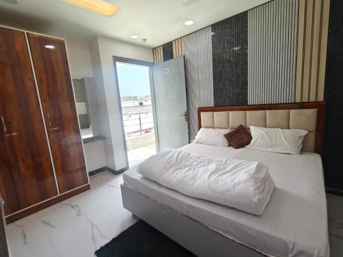 a bedroom with a bed with white sheets and a window at Hotel Jms Inn in Agra