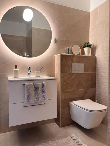 a bathroom with a sink and a toilet and a mirror at Penthouse-Villa Natura in Hegykő