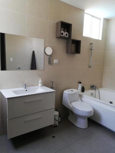 a bathroom with a sink and a toilet and a tub at El Sol de Simbal in Trujillo