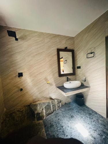 a bathroom with a sink and a mirror on the wall at Hasruk Eco Rest in Yatipauwa