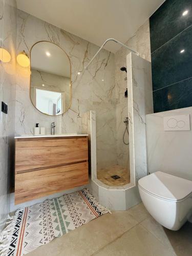 a bathroom with a sink and a toilet and a mirror at Maison Coquelin - Adults Only in La Roche-Guyon
