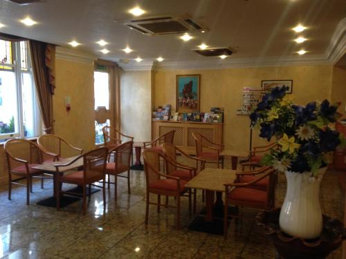 a restaurant with a table and chairs and a vase of flowers at Troy Hotel in London