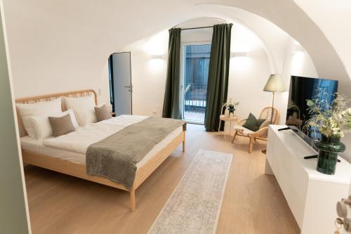a bedroom with a large bed and a living room at GansFein Suites in Wels