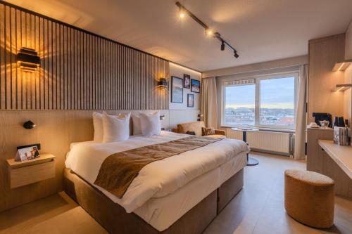 a hotel room with a large bed and a large window at Skotel The Hague, Hotelschool The Hague in Scheveningen