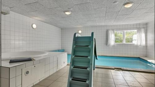 a bathroom with a tub and a swimming pool at Villavilla 247 - Ebeltoft, Østjylland in Ebeltoft