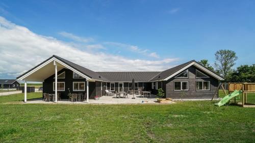 a black house with a playground in the yard at Villavilla 451 - Grenå Strand, Østjylland in Grenå