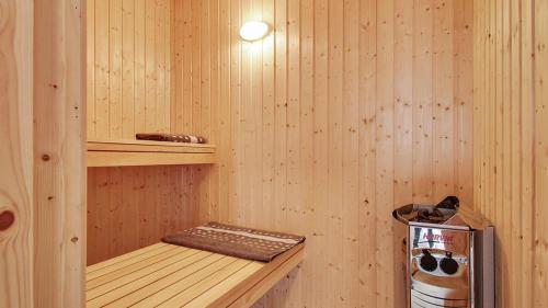 a sauna with a wooden paneled walls and a stove at Villavilla 386 - Ebeltoft, Østjylland in Ebeltoft