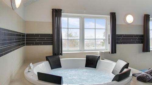 a bath tub with two chairs and a window at Villavilla 386 - Ebeltoft, Østjylland in Ebeltoft