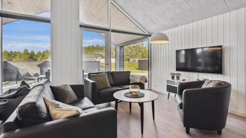 a living room with a couch and chairs and a tv at Villavilla 591 - Rømø, Sydjylland in Høm
