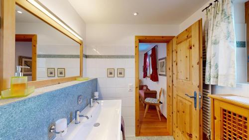 a bathroom with a sink and a large mirror at Apartment Macun in Silvaplana