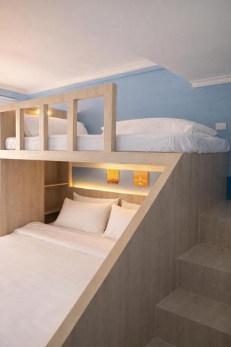 two bunk beds in a small room with stairs at R4R RoomforRest Boutique Hotel Bangsaen Beach in Ban Laem Thaen