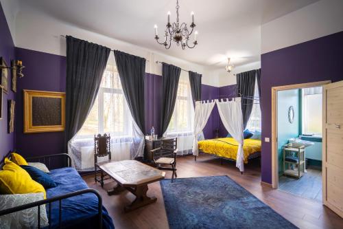 a bedroom with purple walls and a bed and a mirror at Bērzgala Viesu Nams in Stradi