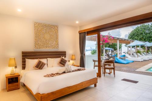 a bedroom with a bed and a view of a patio at AMP Beach House in Nusa Penida