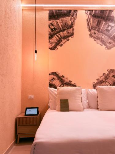 a bedroom with a bed with a tablet on it at Bìfara Rooms in Palermo