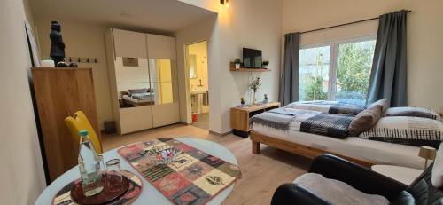a bedroom with a bed and a table and a window at Gästehaus Hähnchenbach in Kelberg
