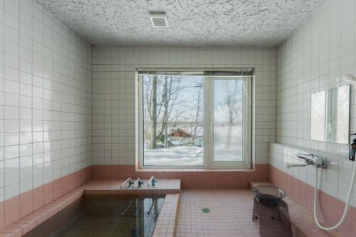 a bathroom with a tub and a window at Shirarutoro Villa in Shibecha