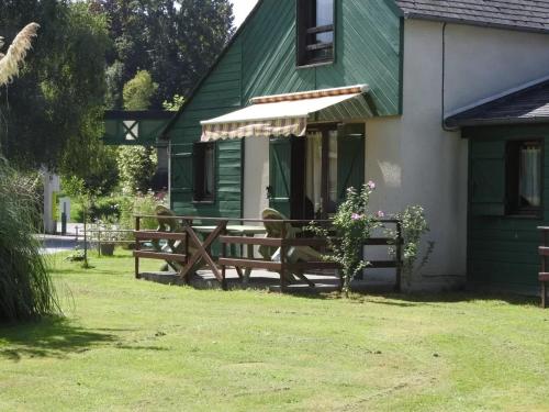 a green house with a bench and an umbrella at ZEcamping 3 étoiles piscine animaux acceptés in Montaut