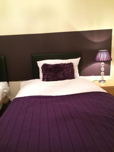 a bedroom with a purple bed with a purple blanket at B&B on Ballyneety Golf Course in Limerick
